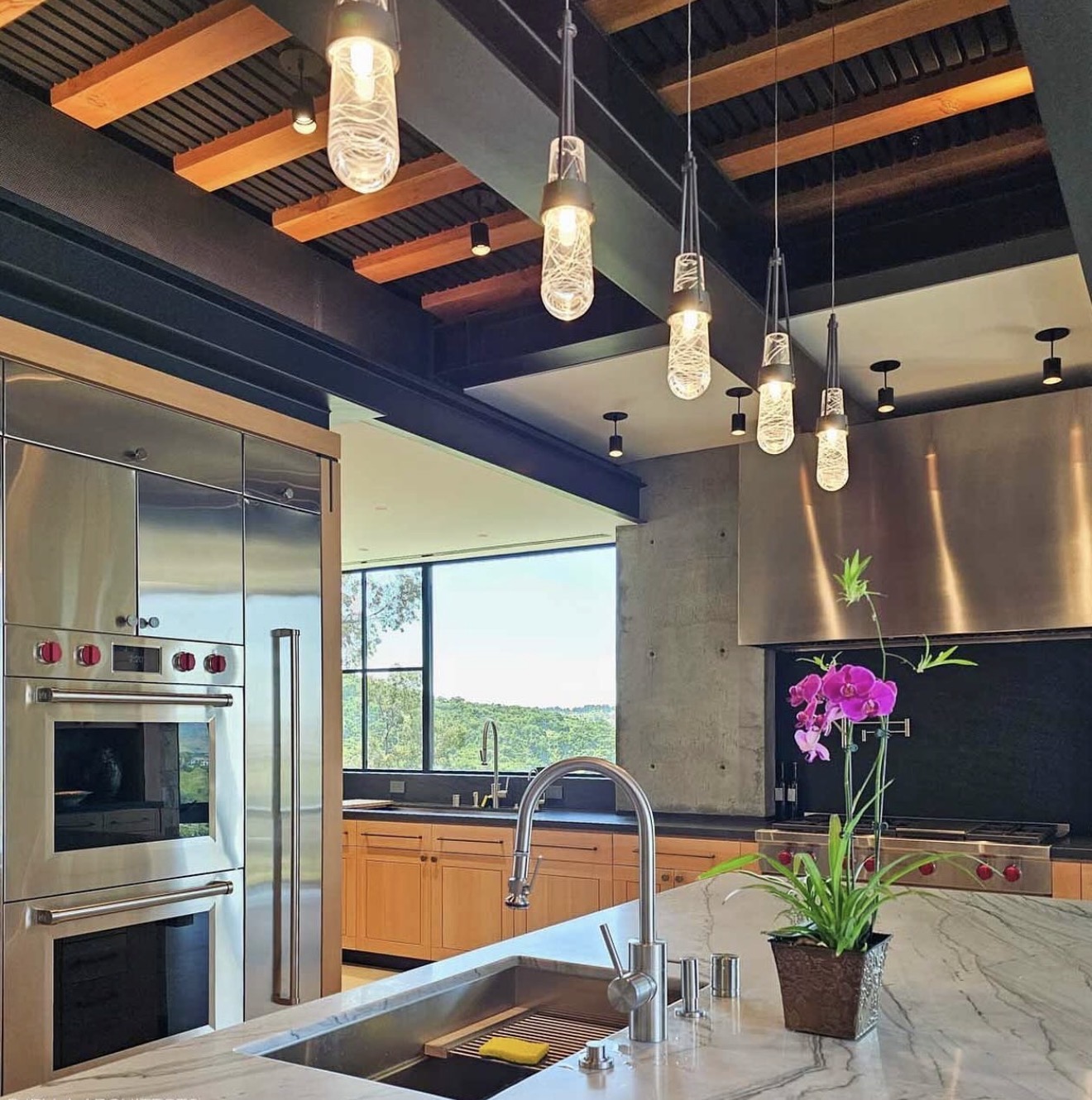 Designer kitchen with custom pendant lighting and exposed wood beams