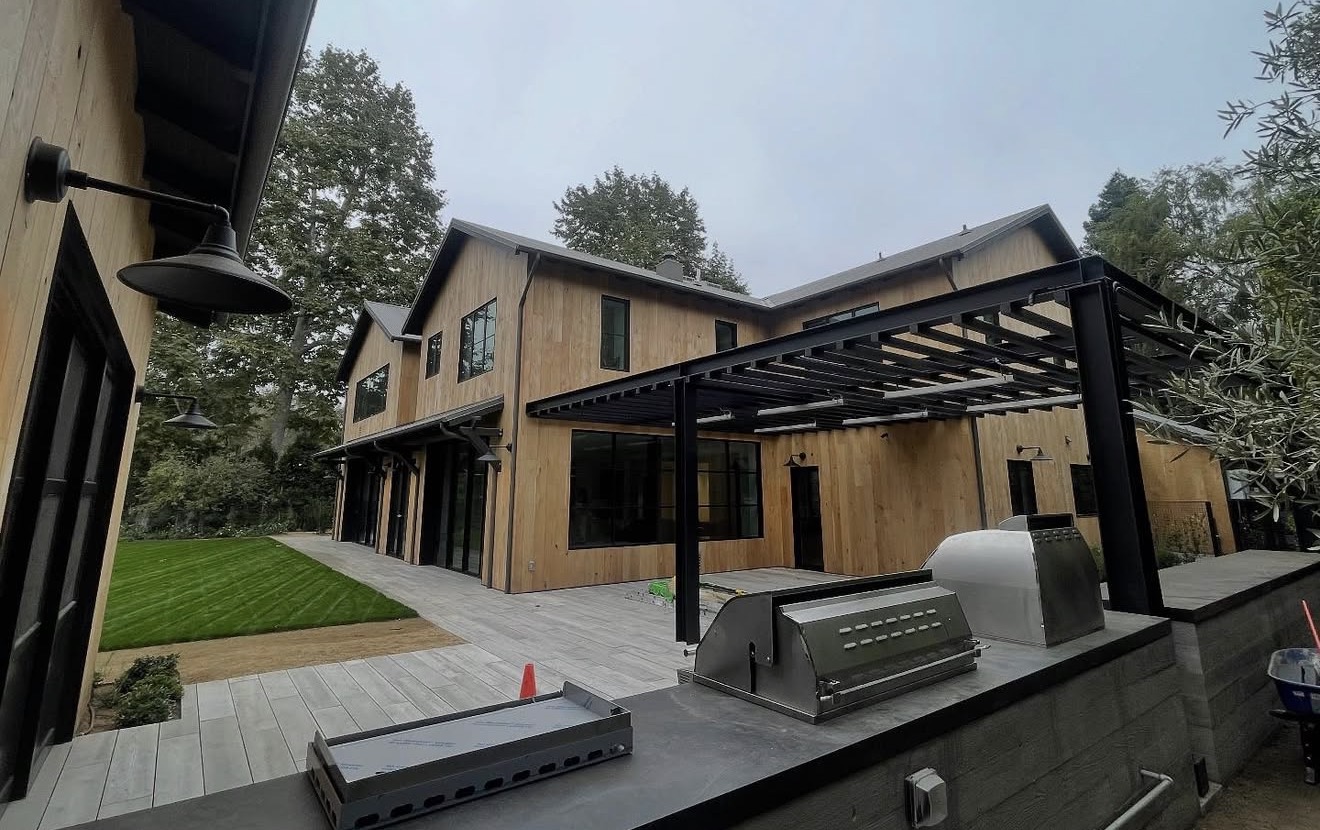 Custom modern farmhouse with pergola and exterior sconce lighting